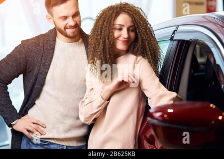 jeune homme et femme choisissant une voiture de luxe pour voyager dans l'agence. gros plan photo, bonheur, service, style de vie, intérêt, famille, amitié, mieux Banque D'Images
