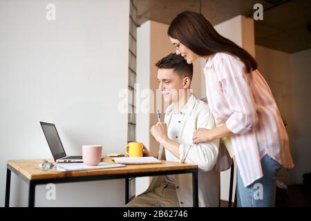 jeune couple utilisant un ordinateur portable à la maison, regarder un webinaire, atelier, gros plan photo vue latérale. stylisation familiale, séminaire de formation. photo vue latérale Banque D'Images