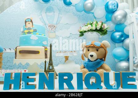 Fête d'anniversaire pour garçon avec décoration aux couleurs pastel bleutées. Décor avec thème aviateur, ours en peluche, nuages, bonbons. Table de bonbons délicate avec beau fu Banque D'Images