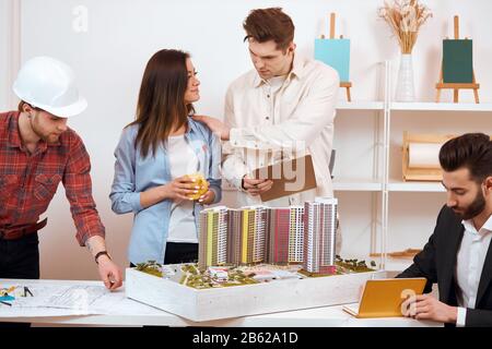 blond gars tenant un dossier et mettant sa main sur l'épaule de son collègue, l'applaudisse, la soulevant pour le projet réussi, bien fait, bon jo Banque D'Images