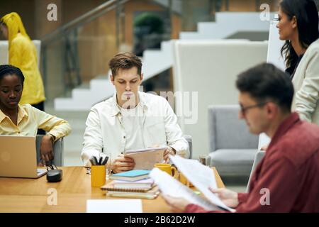 jeunes discutant d'un nouveau plan d'affaires prospères. photo de gros plan, programme de lecture de jeune patron, adoption de l'ordre du jour, rapport. photo de gros plan. Banque D'Images
