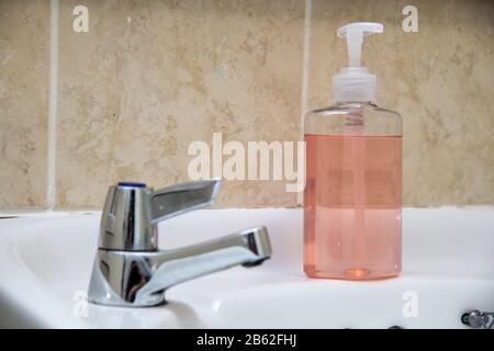 Aseptisant à main rose clair dans un flacon de pompe transparent isolé. L'assainisseur pour les mains est utilisé pour tuer les germes, le coronavirus, etc Banque D'Images