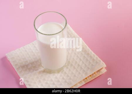 Fraîchement Uni yougurt fait maison en verre sur fond rose, espace de copie. Boisson laitière fermentée froide probiotique. Banque D'Images