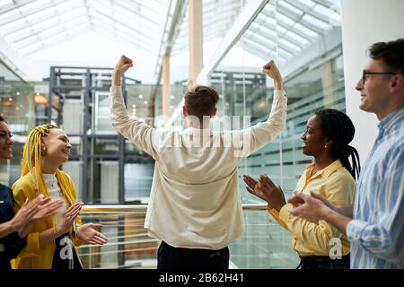jeune gars avec des bras levés montrant sa force, puissance. victoire, compagnie gagnante, affaire réussie. photo de clôture. promotion. bonne chance Banque D'Images