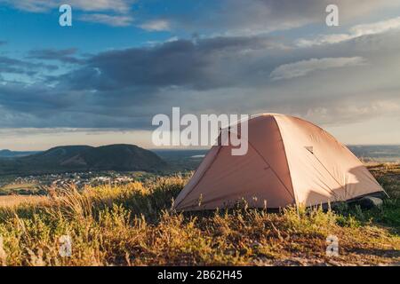 Lever de soleil majestueux dans le paysage des montagnes. Tente solitaire sur un sommet de montagne Banque D'Images