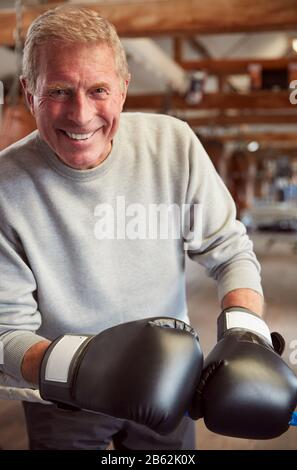 Caleçons Hommes Souriants En Salle De Gym Portant Des Gants De Boxe Penchant Sur Des Cordes De Boxe Ring Banque D'Images