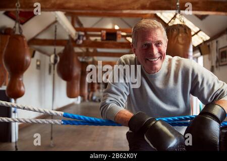 Caleçons Hommes Souriants En Salle De Gym Portant Des Gants De Boxe Penchant Sur Des Cordes De Boxe Ring Banque D'Images