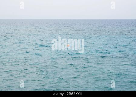 Bouée rouge flottante en mer Méditerranée. Marquer la fin d'une zone de baignade sûre. Banque D'Images