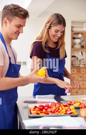 Étudiants Adultes Hommes Et Femmes Préparation Des Ingrédients Pour La Cuisine En Cuisine En Cuisine Banque D'Images