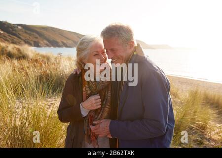 Bras De Couple Actif Affectueux Dans Le Bras Marchant À Travers Dunes De Sable Banque D'Images