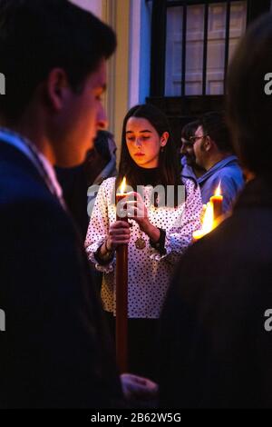 Fille tenant une bougie pendant la procession de la semaine Sainte (Semana Santa) à Séville, Espagne Banque D'Images