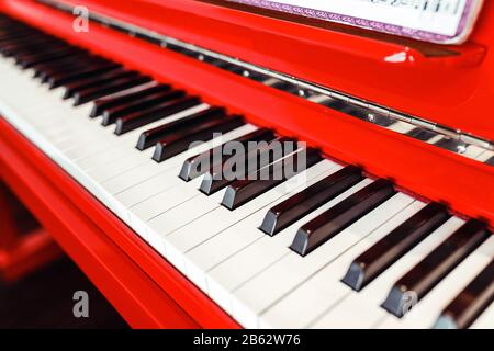 Piano rouge avec des touches de gros plan avec des notes musicales, personne Banque D'Images
