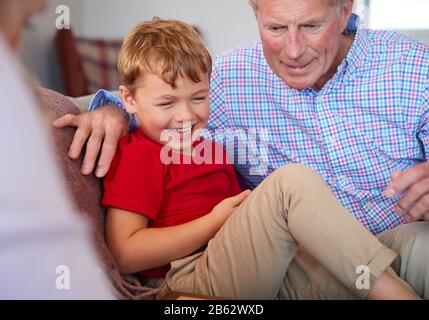 Les Grands-Parents Jouent À Board Game Of Drafts Avec Leurs Petits-Enfants À La Maison Banque D'Images