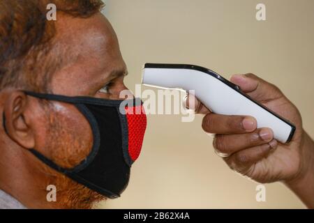 Dhaka, Bangladesh. 9 mars 2020. Un homme bangladais utilise un thermomètre infrarouge pour vérifier la température d'un visiteur qui arrive à un bureau d'entreprise à Dhaka, au Bangladesh, le 09 février 2020. Le Bangladesh a annoncé les premiers cas confirmés de coronavirus dans le pays après que trois personnes ont testé un virus infectieux positif dans la capitale Dhaka dimanche. Crédit: Suvra Kanti Das/Zuma Wire/Alay Live News Banque D'Images