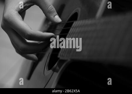 Jeune fille jouant de la guitare de près. Banque D'Images