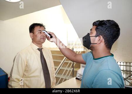 Dhaka, Bangladesh. 9 mars 2020. Un homme bangladais utilise un thermomètre infrarouge pour vérifier la température d'un visiteur qui arrive à un bureau d'entreprise à Dhaka, au Bangladesh, le 09 février 2020. Le Bangladesh a annoncé les premiers cas confirmés de coronavirus dans le pays après que trois personnes ont testé un virus infectieux positif dans la capitale Dhaka dimanche. Crédit: Suvra Kanti Das/Zuma Wire/Alay Live News Banque D'Images