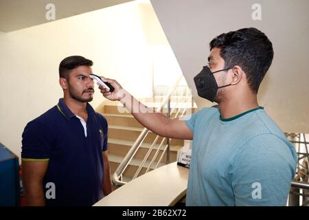 Dhaka, Bangladesh. 9 mars 2020. Un homme bangladais utilise un thermomètre infrarouge pour vérifier la température d'un visiteur qui arrive à un bureau d'entreprise à Dhaka, au Bangladesh, le 09 février 2020. Le Bangladesh a annoncé les premiers cas confirmés de coronavirus dans le pays après que trois personnes ont testé un virus infectieux positif dans la capitale Dhaka dimanche. Crédit: Suvra Kanti Das/Zuma Wire/Alay Live News Banque D'Images