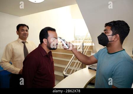 Dhaka, Bangladesh. 9 mars 2020. Un homme bangladais utilise un thermomètre infrarouge pour vérifier la température d'un visiteur qui arrive à un bureau d'entreprise à Dhaka, au Bangladesh, le 09 février 2020. Le Bangladesh a annoncé les premiers cas confirmés de coronavirus dans le pays après que trois personnes ont testé un virus infectieux positif dans la capitale Dhaka dimanche. Crédit: Suvra Kanti Das/Zuma Wire/Alay Live News Banque D'Images