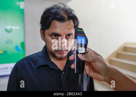Dhaka, Bangladesh. 9 mars 2020. Un homme bangladais utilise un thermomètre infrarouge pour vérifier la température d'un visiteur qui arrive à un bureau d'entreprise à Dhaka, au Bangladesh, le 09 février 2020. Le Bangladesh a annoncé les premiers cas confirmés de coronavirus dans le pays après que trois personnes ont testé un virus infectieux positif dans la capitale Dhaka dimanche. Crédit: Suvra Kanti Das/Zuma Wire/Alay Live News Banque D'Images