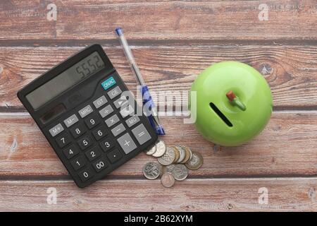 vue de dessus de la calculatrice, des pièces de monnaie et du stylo sur la table Banque D'Images