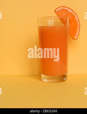 Gros Plan Sur La Boisson Gazeuse Granita Frozen D'Orange Frais Garnie D'Un Coin Orange Et Servie En Verre Avec Paille Rayée Sur Un Pique-Nique En Bois Bleu Vieiné Banque D'Images