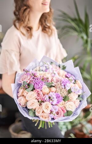 Boutique de fleurs d'Europe. Beau bouquet de fleurs dans les mains de womans. le travail de la fleuriste à un magasin de fleur. La livraison de fleurs fraîches coupées. Banque D'Images