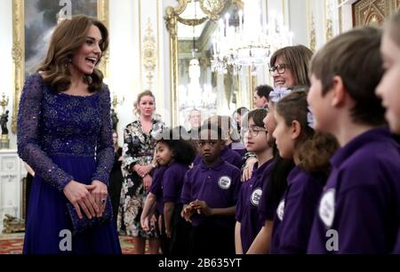 La duchesse de Cambridge parle avec une chorale d'école lorsQu'elle accueille Un Dîner de gala, au palais de Buckingham, à Londres, pour célébrer le 25ème anniversaire de la place du 20e. Banque D'Images