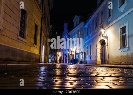 Rue pavée éclairée avec des reflets lumineux sur le pavé dans la vieille ville historique de Prague la nuit Banque D'Images