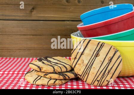 petits gâteaux aux noeuds rétro colorés sur une nappe à damier rouge et blanc Banque D'Images