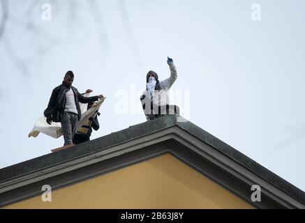 Milan, Italie. 9 mars 2020. Les prisonniers protestent contre le toit de la prison de Saint Vittore à Milan, en Italie, le 9 mars 2020. La violence a éclaté dans plus de 25 centres de détention à travers l'Italie dimanche et lundi, après que les autorités ont réduit les droits des prisonniers dans le cadre d'une stratégie visant à freiner la propagation du coronavirus. Crédit: Daniele Mascolo/Xinhua/Alay Live News Banque D'Images