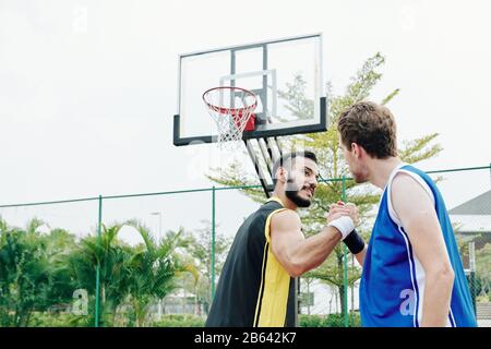 Les joueurs de basket-ball se secouent les mains après avoir joué ensemble sur un terrain de plein air Banque D'Images