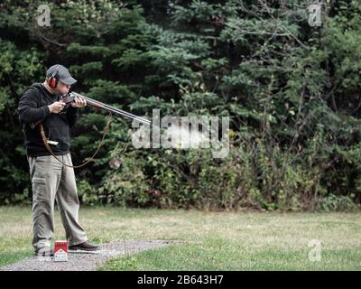 Guy souffle de la fumée dans un fusil de chasse, canon Banque D'Images