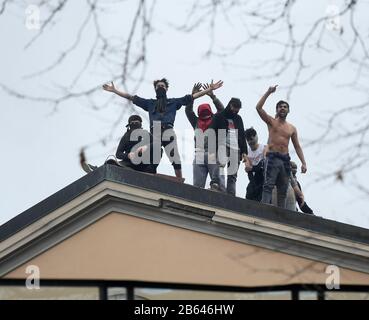 Pékin, Italie. 9 mars 2020. Les prisonniers protestent contre le toit de la prison de Saint Vittore à Milan, en Italie, le 9 mars 2020. La violence a éclaté dans plus de 25 centres de détention à travers l'Italie dimanche et lundi, après que les autorités ont réduit les droits des prisonniers dans le cadre d'une stratégie visant à freiner la propagation du coronavirus. Crédit: Daniele Mascolo/Xinhua/Alay Live News Banque D'Images