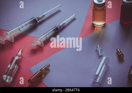 Vaccins, seringues et ampoules sur la table. Ampoules neuves et d'occasion. Préparation à la vaccination. Gros plan. Mise au point sélective. Banque D'Images