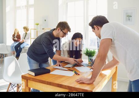 Travail D'Équipe. Les étudiants préparent un emploi analyser discuter des stratégies d'affaires à une table au bureau. Banque D'Images