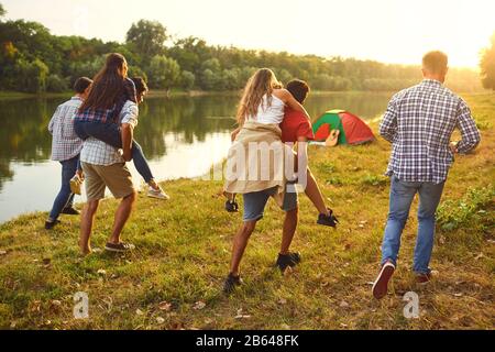 Les amis de s'amuser en marche le long du lac sur une aire de pique-nique. Banque D'Images