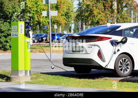 White Toyota Prius Plug-in Hybrid ou PHV branché à la station de charge près de la rue à Seinäjoki, Finlande. 10 Août 2019. Banque D'Images