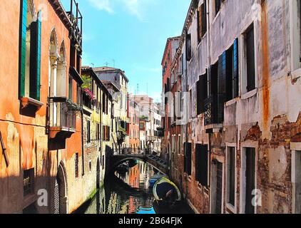 Murs en briques orange rougeâtres de la rue étroite du canal, Venise Italie Banque D'Images