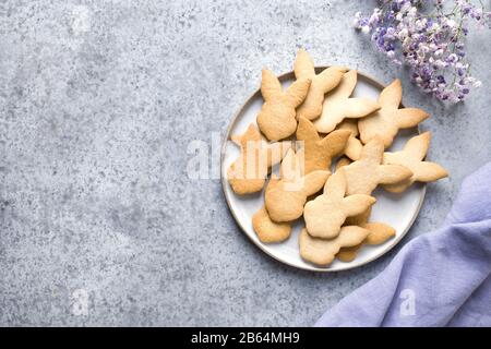 Petits gâteaux en forme de lapins de Pâques sur fond de pierre grise. Vue de dessus avec espace de copie. Banque D'Images