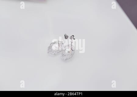 Boucles d'oreilles avec perles et diamants sur fond blanc Banque D'Images