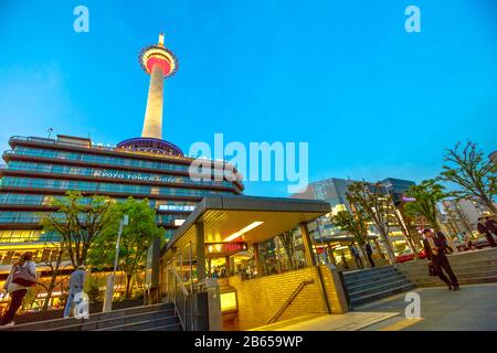 Kyoto, Japon - 27 avril 2017 : bâtiment emblématique de l'hôtel Kyoto Tower avec terrasse d'observation illuminée au crépuscule, vue depuis la place de la gare de Kyoto et le bus Banque D'Images