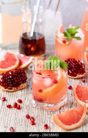 Cocktail Tequila avec jus de grenade et de pamplemousse, teinté de l'arôme d'une branche fraîche de menthe Banque D'Images