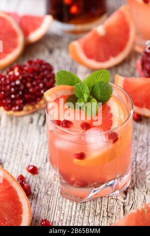 Cocktail Tequila avec jus de grenade et de pamplemousse, teinté de l'arôme d'une branche fraîche de menthe Banque D'Images