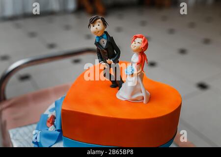 Figurines de la mariée et du marié sur un gâteau de mariage. Banque D'Images