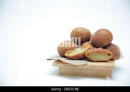 Gros plan sur une plaque en bois d'une boule de riz Gluant traditionnelle coréenne. Chapssal Donuts sur fond blanc. Banque D'Images