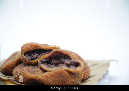 En-cas traditionnels coréens, beignets De boules De riz Gluant avec garnitures de patates douces sur un bol noir Banque D'Images