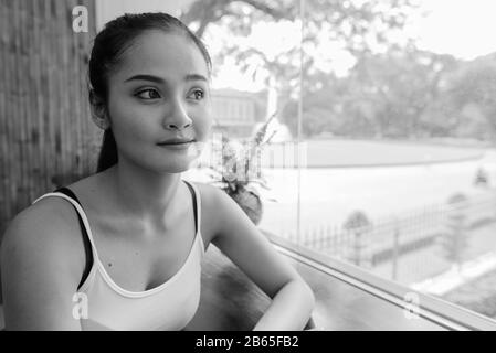 Jeune femme de tourisme asiatique belle assise près de la fenêtre de verre Banque D'Images