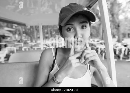 Jeune femme de tourisme asiatique belle faisant le visage drôle à l'intérieur de la voiturette Banque D'Images