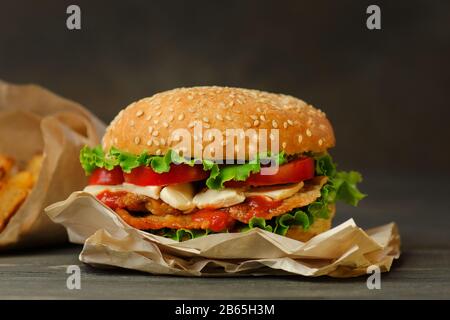 Gros plan sur le hamburger maison. Hamburger avec viande et fromage. Délicieux cheeseburger avec bacon, fromage, laitue et tomate. Espace pour le texte. Banque D'Images