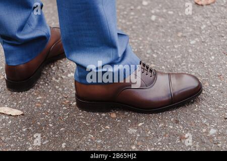 Pieds homme dans des chaussures brunes à l'extérieur. Banque D'Images